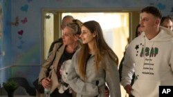 FILE - This photo provided by GPO on Dec. 1, 2023, shows hostage Mia Schem, foreground center, reuniting with her family at Sheba Medical Center in Tel Hashomer, Ramat Gan, Israel. 
