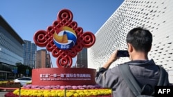 一名男子在北京宣傳一帶一路論壇的路標前拍照。（2023年10月16日）