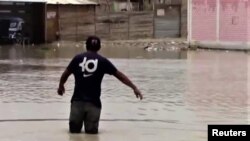 En esta imagen de captura de pantalla de un video publicado por Reuters, un residente en Piura, Perú, camina por una calle inundada debido a las torrenciales lluvias dejadas por el Ciclón Yaku, el 9 de marzo de 2023. Material facilitado por un tercero a Reuters.