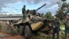 FILE - Members of an ethnic armed forces group known as the Three Brotherhood Alliance check an armored vehicle the group allegedly seized from Myanmar's army outpost on a hill in Hsenwi township in Shan state, Nov. 24, 2023.