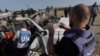 Anggota staf PBB memeriksa bangkai mobil yang digunakan oleh kelompok bantuan World Central Kitchen yang berbasis di AS, yang terkena serangan Israel sehari sebelumnya di Deir al-Balah di Jalur Gaza tengah, 2 April 2024. (AFP)