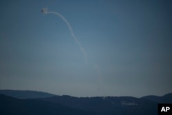 Israel's Iron Dome air defense system fires to intercept an attack from Lebanon over the Galilee region as seen from the Israeli-annexed Golan Heights, July 18, 2024.