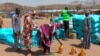 FILE - Sudanese refugees displaced by the conflict in Sudan gather to receive food staples from aid agencies at the Metche Camp in eastern Chad, March 5, 2024. 
