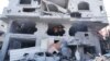 Palestinos dentro de un edificio destruido en un ataque aéreo israelí en el campamento de Nuseirat en el centro de la Franja de Gaza, el lunes 16 de octubre de 2023. [AP]