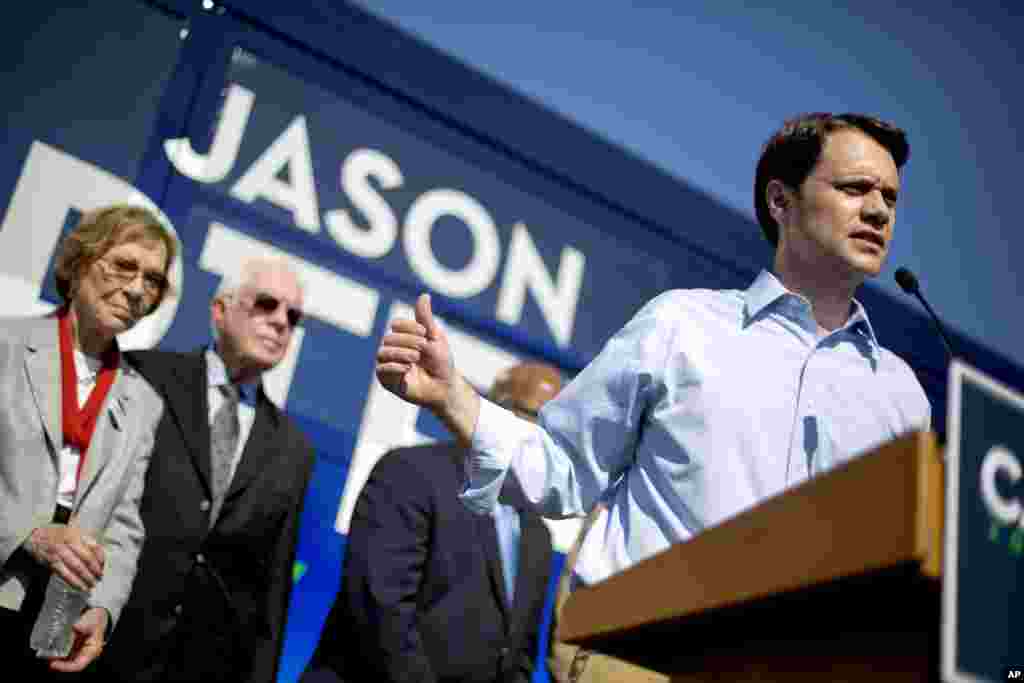 Georgia Democratic gubernatorial candidate Jason Carter speaks during a campaign stop as his grandfather, former President Jimmy Carter and wife Rosalynn, left, look on, Oct. 27, 2014, in Columbus.