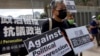 FILE - Pro-democracy activist Lee Cheuk-yan, center, holds placards as he arrives at a court in Hong Kong, April 1, 2021. Hong Kong national security police arrested, March 9, 2023, Lee's wife Elizabeth Tang, herself a labor activist, after visiting her husband in prison.