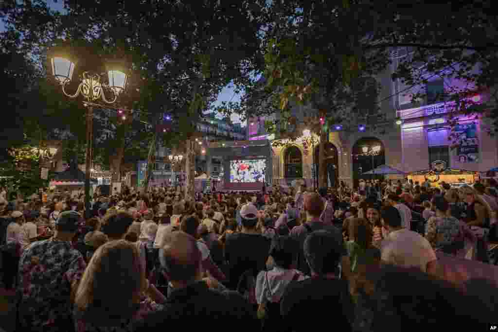 People watch a TV program airing the 2024 Summer Olympics closing ceremony being held at the Stade de France, Aug. 11, 2024, in Paris, France.
