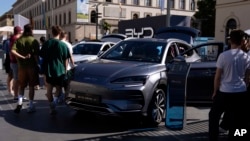 Sejumlah pengunjung memperhatikan mobil listrik buatan produsen China BYD di sebuah pameran motor di Munich, Jerman, 3 September 2023. (Foto: Matthias Schrader/AP Photo)