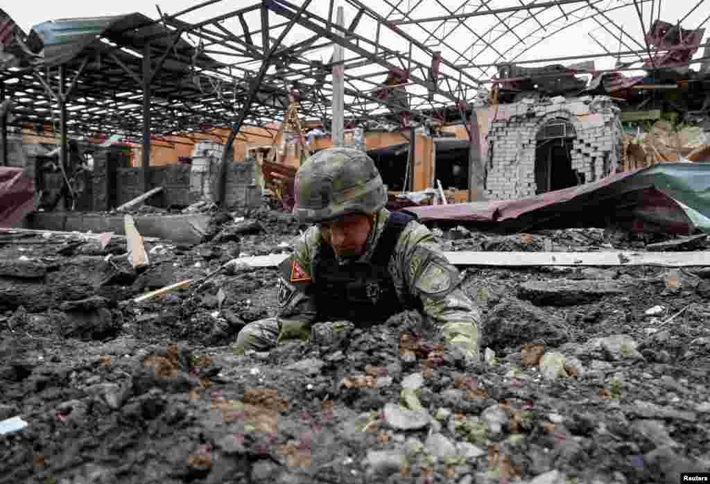 Un miembro del escuadrón de bombas de la policía trabaja en el lugar del ataque ruso, en Járkov, Ucrania, el 22 de mayo de 2024. REUTERS/Sofiia Gatilova