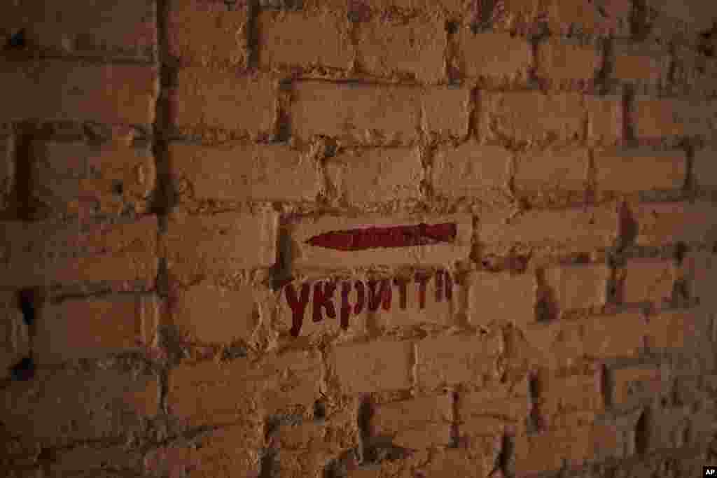 Una señal con la palabra "refugio" en una calle en Kiev, Ucrania, el 11 de marzo de 2023. Hay sacos de arena protegiendo estatuas y barreras antitanque en las calles, trincheras en los bosques cercanos y avisos de minas terrestres en el monte. Las señales pintadas en las paredes indican el refugio más próximo, mientras las sirenas antiaéreas suenan ocasionalmente en la ciudad, que a veces sufre ataques con misiles. 