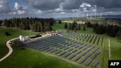 FILE - This May 8, 2024, photo shows a solar farm and wind turbines in Mont Soleil mountain, above Saint-Imier, Switzerland.