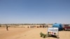 FILE - People cross the border between Sudan and Chad at the border post in Adre on April 11, 2024. 