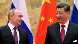 Presiden China Xi Jinping, kanan, dan Presiden Rusia Vladimir Putin berpose untuk foto selama pertemuan mereka di Beijing, China, pada 4 Februari 2022.