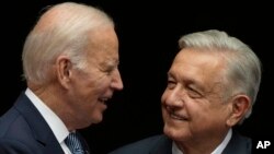 ARCHIVO: Los presidentes de Estados Unidos, Joe Biden, y México, Andrés Manuel López Obrador, sonríen durante una reunión el 9 de enero en la Ciudad de México.