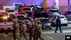 Agentes caminan en un estacionamiento del centro comercial Cielo Vista Mall, donde una persona murió y tres fueron heridas en un tiroteo masivo, el 15 de febrero de 2023, en El Paso, Texas. 