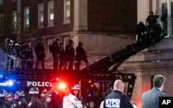 Policías de Nueva York utilizan un vehículo táctico para llegar a un piso superior del edificio Hamilton en el campus de la Universidad de Columbia, el martes 30 de abril de 2024 en Nueva York, Estados Unidos.