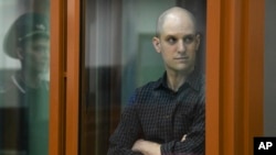 Wall Street Journal reporter Evan Gershkovich stands in a glass cage in a courtroom in Yekaterinburg, Russia, June 26, 2024.