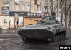 Ukrainian service members ride a BMP-2 infantry fighting vehicle on an empty street, as Russia's attack on Ukraine continues, in the frontline city of Bakhmut, Ukraine, Feb. 27, 2023.