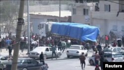 People chase behind a convoy of aid trucks driving into Gaza from Rafah crossing, Apr. 9, 2024. 