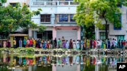 La gente hace cola para votar fuera de una cabina de votación durante la quinta ronda de las elecciones nacionales de varias fases en Howrah, India, el 20 de mayo de 2024.