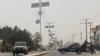 Personel keamanan Taliban (kanan) memblokir jalan di Mazar-i-Sharif , menyusul ledakan di kantor gubernur Taliban Mohammad Dawood Muzammil, di provinsi Balkh Afghanistan, 9 Maret 2023. (Atif ARYAN/AFP)