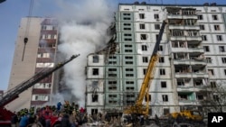 Los bomberos trabajan para extinguir un incendio luego de un ataque ruso en un edificio residencial en Uman, en el centro de Ucrania, el viernes 28 de abril de 2023. (Foto AP/Bernat Armangue)