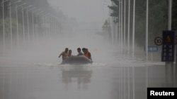 中國河北涿州民眾在滔滔洪水中乘坐橡皮艇逃生。（2023年8月3日）