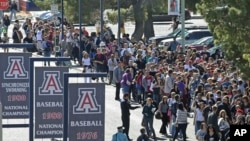 FILE - People line up outside McKale Memorial Center on the University of Arizona campus, Jan. 12, 2011, in Tucson, Ariz.