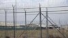 FILE - A hangar can be seen behind barbed wire fencing at Bagram Air Base after the U.S. military left the facility, in Parwan province, north of Kabul, Afghanistan, July 5, 2021.
