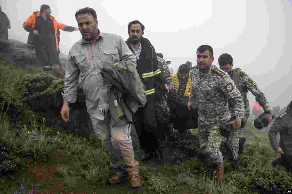 In this photo provided by Moj News Agency, rescue team members carry the body of a victim after a helicopter carrying Iranian President Ebrahim Raisi crashed in Varzaghan in northwestern Iran, May 20, 2024. 