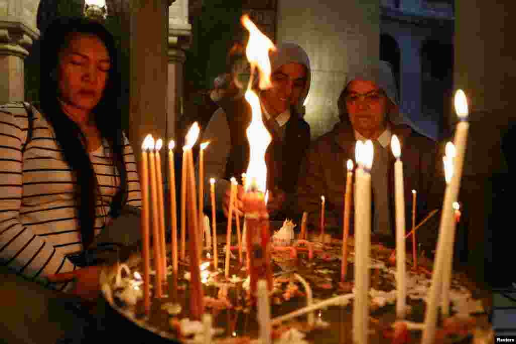 Los fieles rezan en la Iglesia del Santo Sepulcro durante la procesión del Viernes Santo, en la Ciudad Vieja de Jerusalén.