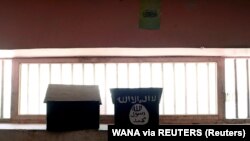 Bendera ISIS yang dilukis di atas rak buku terlihat di sel penjara Pul-e-Charkhi di Kabul, Afghanistan, pada 15 September 2021. (Foto: WANA via Reuters)