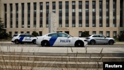 Police cars sit in front of the federal courthouse in Washington, where former president Donald Trump is expected to answer charges after a grand jury returned an indictment for efforts to overturn his 2020 election defeat, Aug. 2, 2023.