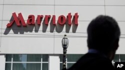 FILE - A person walks past the San Francisco Marriott Union Square hotel on July 11, 2019, in San Francisco, California. Multinational companies such as Amazon, Marriott and Hilton pledged on June 19, 2023 to hire more than 13,000 refugees.