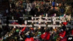 Karangan bunga ditumpuk mengelilingi salib kayu bertuliskan nama-nama korban penembakan massal di SD Robb, Uvalde, Texas, 31 Mei 2022. (Foto: Jae C. Hong/AP Photo)