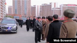 지난달 23일 김정은 북한 국무위원장이 '화성지구 3단계 1만 세대 살림집건설착공식'에 참석했다며 관영매체들이 공개한 영상에서, 독일제 벤츠 차량(왼쪽)을 타고 도착한 김 위원장이 참석자들과 악수하고 있다. 도요타 등 다른 외국 차량도 보인다. (자료사진)