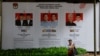 ILUSTRASI - Seorang pedagang kaki lima membawa barang dagangannya melewati spanduk bergambar paslon presiden dan wakil presiden untuk Pemilu mendatang di Jakarta, 12 Januari 2024. (REUTERS/Willy Kurniawan)