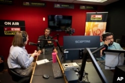 De izquierda a derecha, la invitada Carolina Rodríguez-Greer con el presentador de Mi Familia Vota, Osvaldo Franco, y el ingeniero Daniel Orona transmiten desde el estudio Phoenix de La Campesina, una cadena de radio en español, el 20 de marzo de 2024.