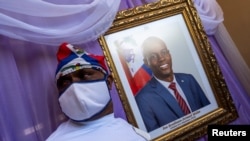 Un hombre aparece junto a un retrato del asesinado presidente haitiano, Jovenel Moïse, colocado en un monumento en el ayuntamiento de Cabo Haitiano, Haití, el 22 de julio de 2021. [REUTERS]