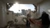 Warga Palestina mengumpulkan barang-barang mereka dari rumah mereka yang rusak pasca serangan udara Israel di Rafah, Jalur Gaza selatan, 27 Januari 2024. (Foto: AP)