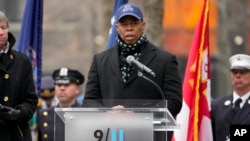 El alcalde de la ciudad de Nueva York, Eric Adams, habla antes de que los dolientes coloquen flores sobre los nombres de las víctimas del atentado con bomba en el World Trade Center de 1993 durante una ceremonia en el Memorial del 11 de septiembre, el domingo 26 de febrero de 2023, en Nueva York. (Foto AP/John Minchillo)