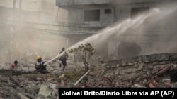 Bomberos apagan un incendio después de una explosión, el lunes 14 de agosto de 2023, en San Cristóbal, República Dominicana. 