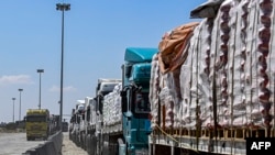Egyptian trucks carrying humanitarian aid bound for the Gaza Strip queue outside the Rafah border crossing on the Egyptian side on March 23, 2024. UN secretary-general says it is 'moral outrage' that aid is being blocked from being sent into Gaza.