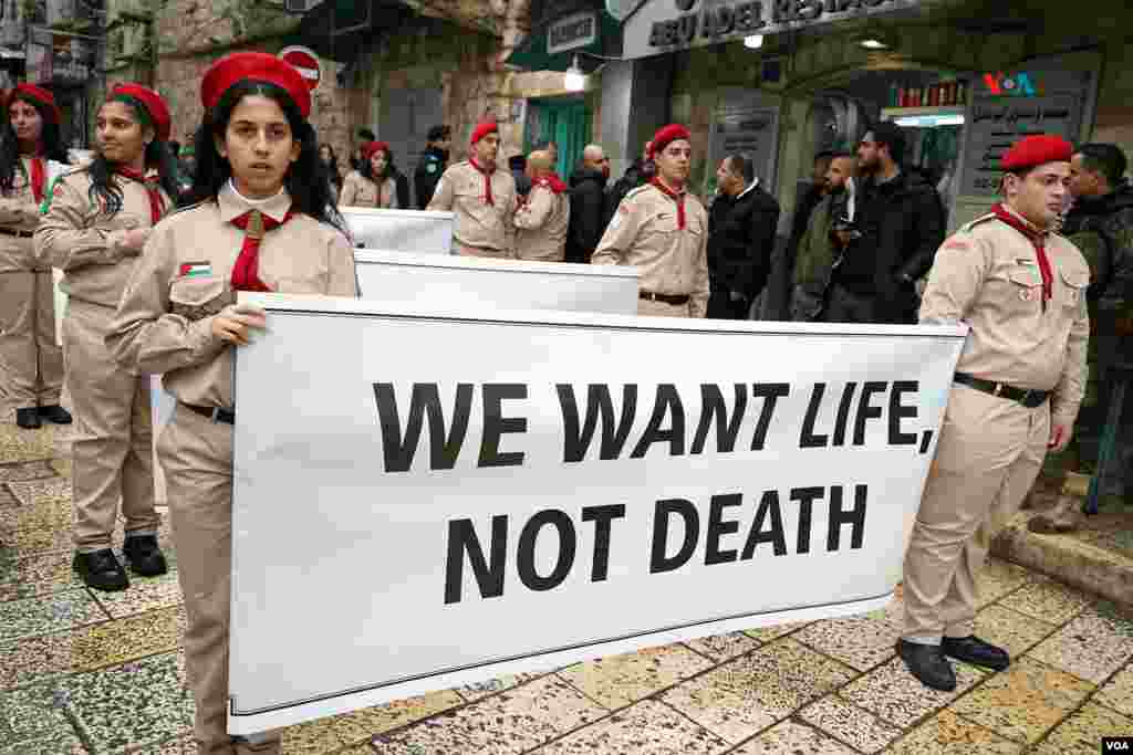 “Nosotros queremos vivir, no morir”, reza uno de los carteles que portaban los niños palestinos en la ciudad de Belén, durante una Navidad sin festejos, casi luctuosa, en recordación a las miles de personas inocentes -muchas de ellos niños-, que han muerto por los bombardeos israelíes a la Franza de Gaza.