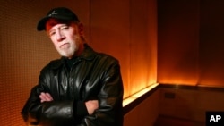 FILE - Actor and comedian George Carlin poses in a New York hotel, March 19, 2004. Carlin's estate is suing a media company over an hour-long special which uses a synthesis of the late comedian to deliver commentary on current events.
