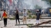FILE - A demonstrator gestures as protesters clash with Border Guard Bangladesh and the police outside the state-owned Bangladesh Television as violence erupts across the country after anti-quota protests by students, in Dhaka, Bangladesh, July 19, 2024. 