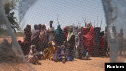 FILE - Somali refugees are seen through a discarded mosquito net as they gather in the new arrivals area of the Dadaab refugee camp near the Kenya-Somalia border, in Garissa county, Kenya, Jan. 17, 2023.