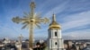 Dos hombres instalan una cruz restaurada en la cúpula de la Catedral de Santa Sofía en Kiev, Ucrania, el 21 de diciembre de 2023.