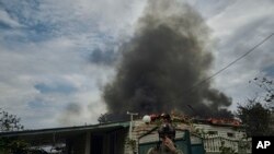 A Ukrainian soldier passes by a burning house after the Russian shelling close to the front line in Seversk, Donetsk region, Ukraine, Sept. 1, 2023.