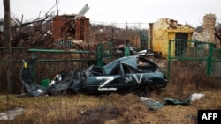 Un vehículo destruido marcado con el signo "Z" que representa la agresión de Rusia contra Ucrania y los edificios demolidos como resultado de los bombardeos se ven en la aldea de Kamenka, en la región de Kharkiv en Ucrania, el 26 de febrero de 2023.